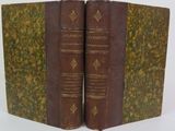 two old books sitting on top of each other on a white surface