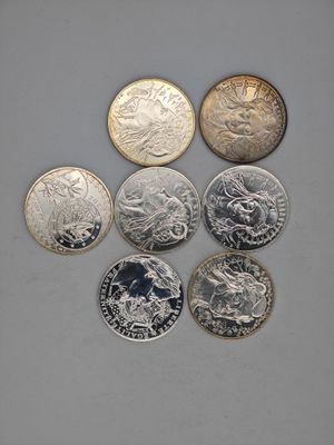 six different british coins sitting on top of each other on a table