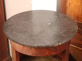a small table with a black marble top in a room