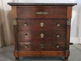 a wooden chest of drawers with a marble top