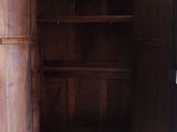 une armoire en bois dont la porte est ouverte, dans un garage