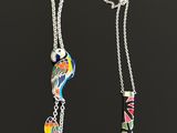 two necklaces with different designs on them sitting next to each other