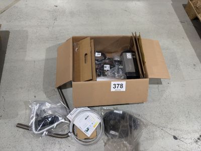 une boîte contenant des articles variés, posée par terre dans un magasin