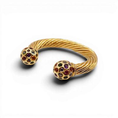 un gros plan sur un bracelet en or orné de deux boules