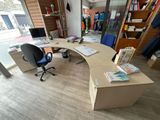 a desk with a chair and a book shelf in the corner