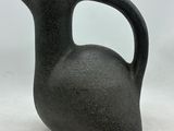 a black vase that is sitting on a table