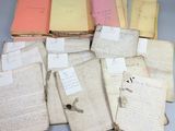 une pile de vieux livres recouverts de feuilles, posée sur une table