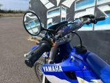 a blue motorcycle parked in front of a graffiti covered wall