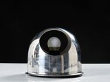 a silver object on a white table with a black background