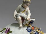 a figurine of a boy sitting on top of a cake