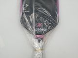 a close up of a tennis racket wrapped in plastic on a white surface