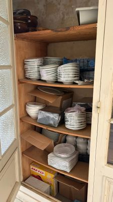 de nombreuses assiettes et bols empilés sur les étagères du garde-manger