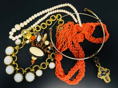 de nombreux colliers et bracelets de styles variés posés sur un fond noir