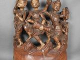 une image représentant une sculpture en bois représentant un groupe de personnes sur une souche d'arbre