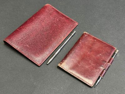 two pieces of leather with a pen sitting on top of it