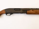 un fusil de chasse au canon en bois posé sur une surface blanche