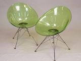 une paire de chaises vertes aux pieds chromés sur fond blanc