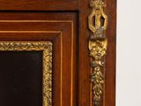 an antique wooden cabinet with a mirror and gold trimmings