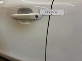 a sticker on the door handle of a white car