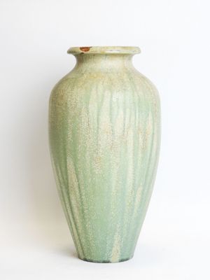 a green vase that is sitting on a white surface