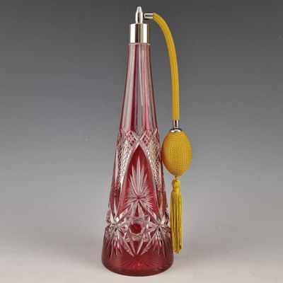 une bouteille en verre rouge avec une poignée jaune et une boule jaune