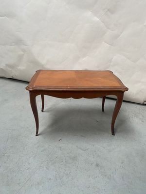 une petite table avec un plateau en bois sur un sol en ciment