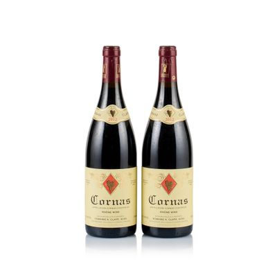 two bottles of red wine sitting next to each other on a white surface