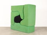 an image of a green chair with a black cushion on it