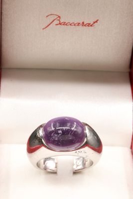 an image of a ring with a purple stone in a box