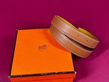 a brown belt sitting on top of an orange box on a pink surface