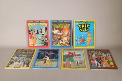 several children ' s books are lined up on a white surface