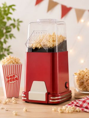 une photo d'une machine à pop-corn rouge posée sur une table en bois