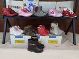 many pairs of children ' s shoes sitting on a shelf
