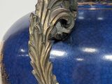 a large blue vase with a gold decoration on it