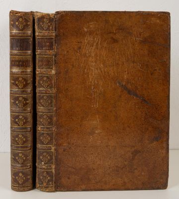 an old book sitting on top of a table next to a white wall