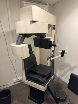 une photo d'une salle de consultation avec une chaise et un écran