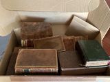 une boîte remplie de livres posée sur une table, avec une pancarte sur laquelle on peut lire « Sortir des sentiers battus »
