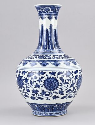 Vase bleu et blanc orné de fleurs et de vrilles sur fond gris