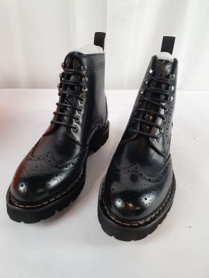 black leather boots with black soles on a white surface