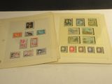 deux pages d'un livre, sur lesquelles figurent des timbres, posées sur une table