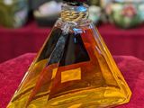 a close up of a bottle of perfume on a red surface