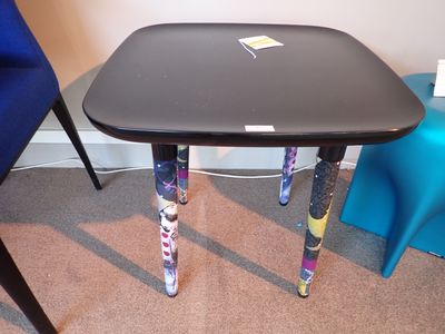 une petite table recouverte d'autocollants, dans un coin de la pièce