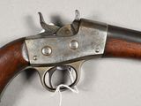 an old gun with a wooden handle on a white surface