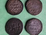 three old coins with designs on them on a green surface