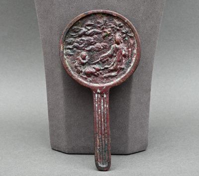 une image représentant un miroir en bronze posé sur un socle