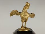 a statue of a rooster on a wooden base