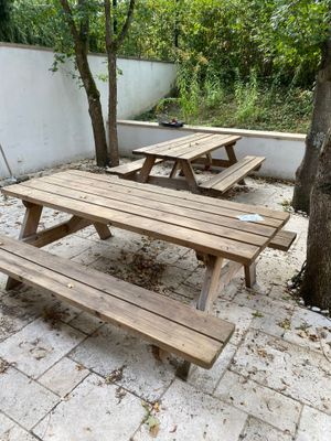two wooden picnic tables in the middle of a courtyard
