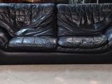 trois fauteuils inclinables en cuir noir dans une pièce équipée d'une bibliothèque