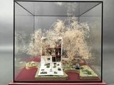 a display case with a model of a house inside of it