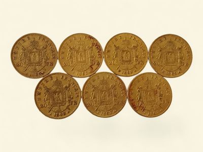 six pièces d'or sont disposées en ligne sur une surface blanche